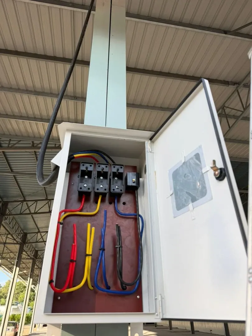 An open distribution board with colour-coded conduits entering the enclosure